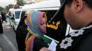 Un policía de la moral iraní comprueba la identidad de una mujer detenida durante las protestas en Teherán