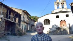 Jose, vecino de 101 aos, junto a la iglesia y algunas de las viviendas tradicionales abandonadas