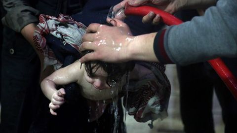 Un grupo de sanitarios del hospital de Duma lavan con agua a un beb afectado tras el ataque de sbado con gas cloro
