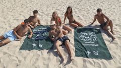 Un grupo de jóvenes aficionados con las toallas del Racing en un día de playa. 