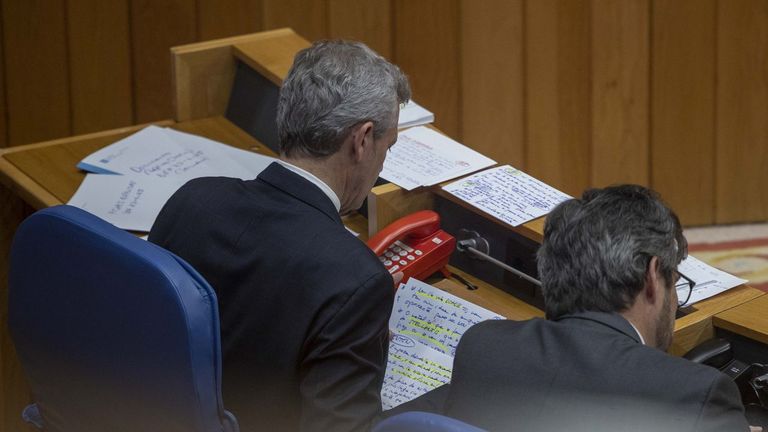 Alfonso Rueda, junto al conselleiro Diego Calvo, revisando notas personales.