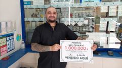Marcos Puerta, de la lotera de la calle Joaqun Costa, en Pontevedra, exhibe el cartel del premio de El Milln que reparti