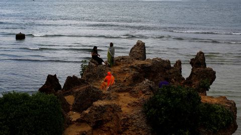 Mujeres descansando en una roca junto al mar, Kenia