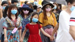 Turistas extranjeros se tapan con mscaras contra el coronavirus durante una visita al templo del Buda Esmeralda, en la ciudad tailandesa de Bangkok
