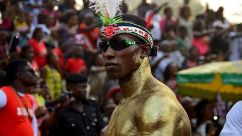 Un hombre pintado de oro se luce en el festival de Calabar en Nigeria