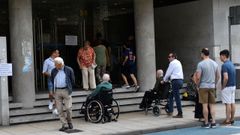 Personas en silla de ruedas, a la puerta del edificio sindical de Lugo.