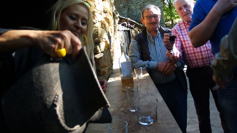 Una cosechera sirve vino con una jarra de Gundivós en una bodega del conjunto etnográfico