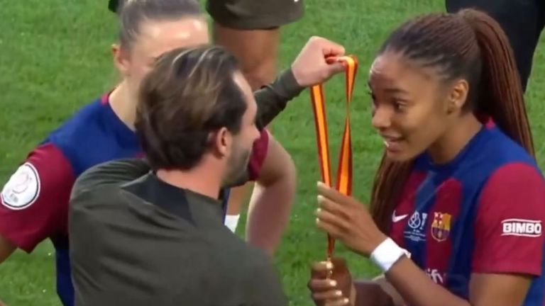 Salma Paralluelo mira con incredulidad a un miembro del cuerpo técnico que le hace entrega de su medalla.
