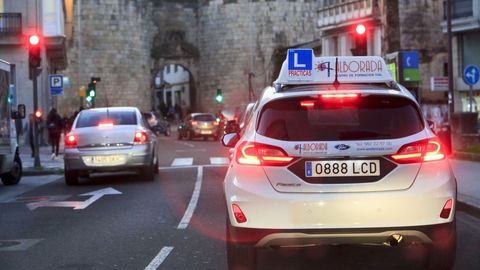 Un coche de autoescuela circulando por la ciudad de Lugo