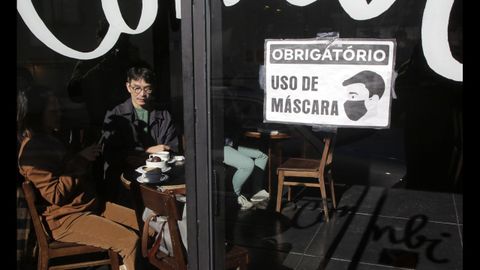 En una cafetería de Oporto, dos personas conversan sin mascarilla