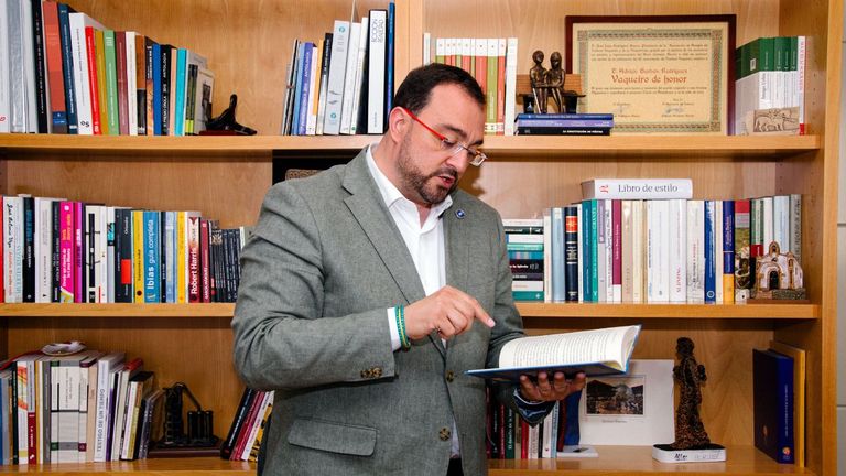 El presidente del Principado, Adrián Barbón, con el libro «Toda una vida» de Miguel Ángel Revilla en su apartamento. El presidente cántabro deja en su obra por testigo de su funeral al mandatario asturiano