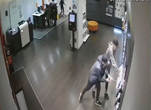 Dos ladrones grabados por una cámara de seguridad mientras arrancan los móviles en una tienda de telefonía