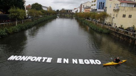Dos piragüistas del club Quixós mostraron en Monforte en el río Cabe la frase  Monforte en negro  formada por grandes letras blancas
