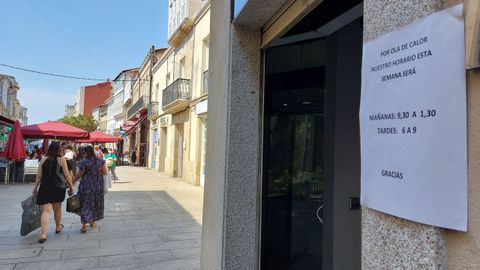 Un letrero en un comercio de la calle Cardenal de Monforte avisa de un cambio de horarios que estará vigente toda la semana para adaptarse a la ola de calor