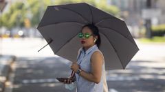 Una mujer se protege del sol con un paraguas en plena ola de calor