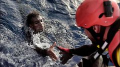 Un activista de Proactiva Open Arms auxilia a un migrante en aguas del Mediterrneo