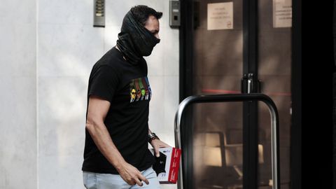 Un agente de la Guardia Civil entra con material informático en la sede de la empresa Acciona en Valencia