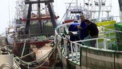 Marineros de un pesquero gallego trabajando a bordo, amarrados en puerto (foto de archivo)