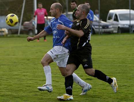 Marz�n, a la derecha, conduce el bal�n ante la oposici�n de un futbolista del Burela.