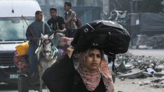 Una mujer palestina desplazada de Yabalia se dirige a la ciudad de Gaza con sus pertenencias.