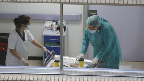 Dos trabajadores sanitarios del Juan Cardona preparndose antes de entrar en una habitacin de la planta de aislados