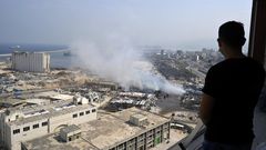 Un libanés observan la extinción del incendio otro gran incendio en el almacén donde la Cruz Roja Internacional guardaba cerca del puerto la ayuda humanitaria volvió a despertar los fantasmas del desastre.