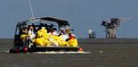 Un grupo de trabajadores navegan por la costa de Venice tras recoger el petróleo que la plataforma de British Petroleum expulsa a diario en el golfo de México