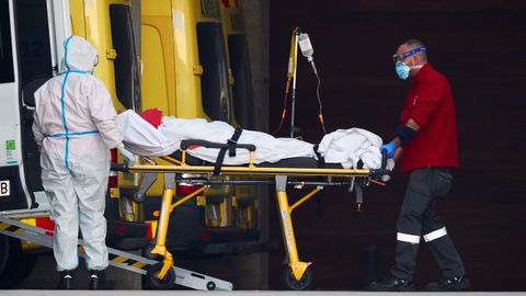 Dos profesionales sanitarios trasladan a un paciente en el hospital de Bellvitge, en Barcelona