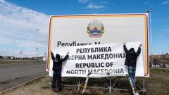 Dos operarios colocan la nueva denominacin en la frontera entre Grecia y Macedonia