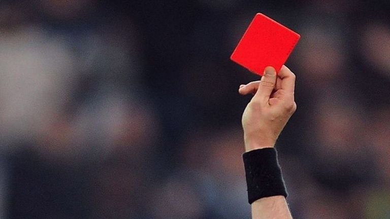 Un árbitro muestra una tarjeta roja