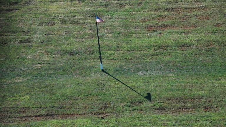 Una bandera estadounidense en medio de las fosas comunes de miles de enterrados, en Hart Island. 