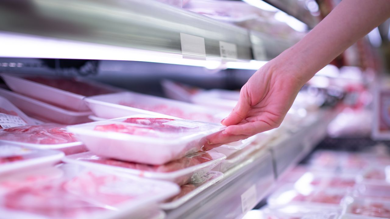 Una mujer, sosteniendo una bandeja de carne en un supermercado, en una imagen de archivo.