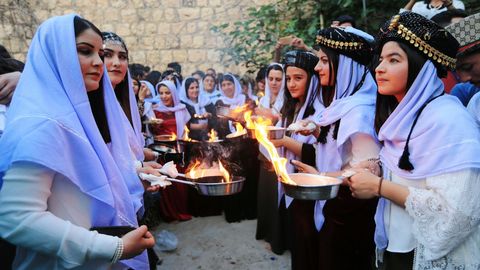 Un grupo de mujeres encienden velas durante una ceremonia en la provincia iraqui de Dohuk