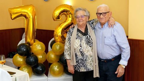 La pareja, sonriente, junto a los números gigantescos con que los sorprendió su familia
