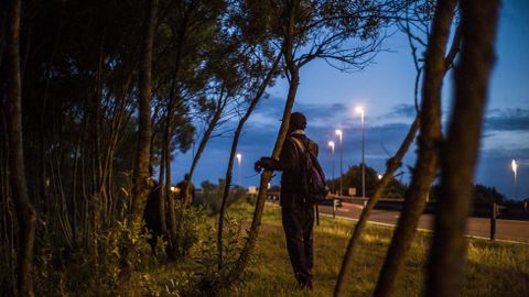 Un inmigrante espera en Calais (Francia)antes de intentar tomar un tren hacia Inglaterra