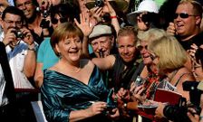 Merkel, de vacaciones, firm ayer autgrafos en la inauguracin del festival de Bayreuth.
