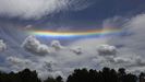 Arco iris horizontal entre nubes visto desde Teo