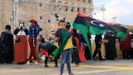 Un niño enarbola una bandera libia en la conmemoración en Trípoli del 10 aniversario del levantamiento popular contra Gadafi