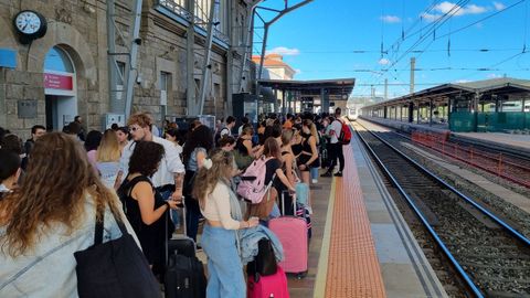 El andn, rebosante de pasajeros a la espera del tren para Vigo.