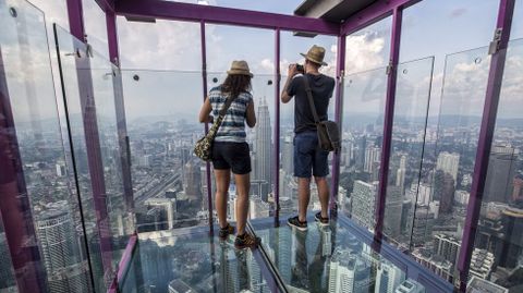 Dos turistas fotografan Kuala Lumpur (Malasia) desde uno de los grandes rascacielos de la ciudad; Kuala Lumpur Tower