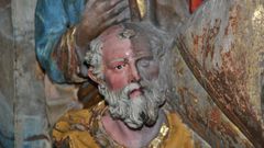 Fotografa de una de las figuras del retablo a medio restaurar, donde se aprecia el cambio.  
