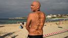 Un hombre posa en Bondi Beach, Australia, con el mensaje:  Tenemos nuestra playa de vuelta 