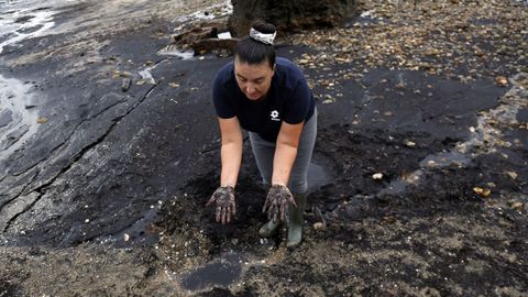 Geno Maneiro muestra el sedimento que cubre la playa.