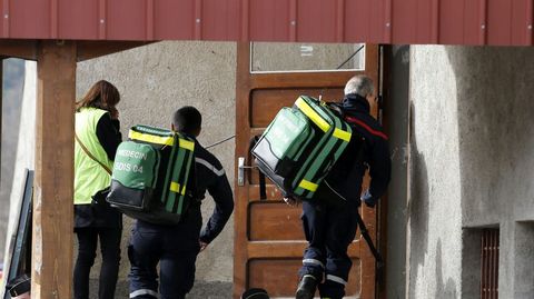 Dos bomberos transportan equipo mdico al interior de un pabelln reconvertido en capilla ardiente en Seyne les Alpes