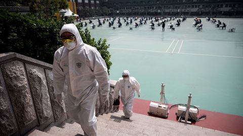 Trabajadores enfundados en equipos de proteccin, durante la celebracin de los exmenes