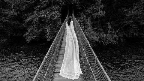 La imagen de boda de Lesmes juega con la longitud del vestdo de la novia y el puente en el que se sitúa.