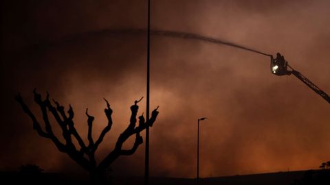 Un bombero trabaja para apagar el incendio que afecta al museo histrico de Seat en Barcelona