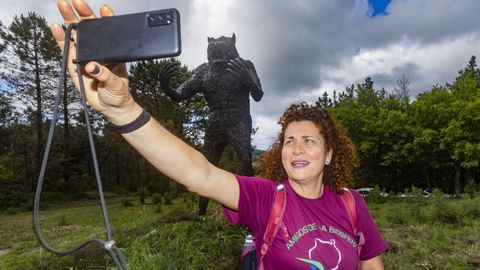 Una peregrina se hace un selfi con la imponente estatua de Vákner al fondo.