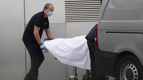 Miembros de los servicios funerarios recogen un cádaver del Hospital de Mataro