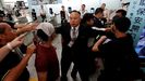 Un miembro del aeropuerto de Hong Kong intenta contener a los manifestantes ante el mostrador de una compaa area 